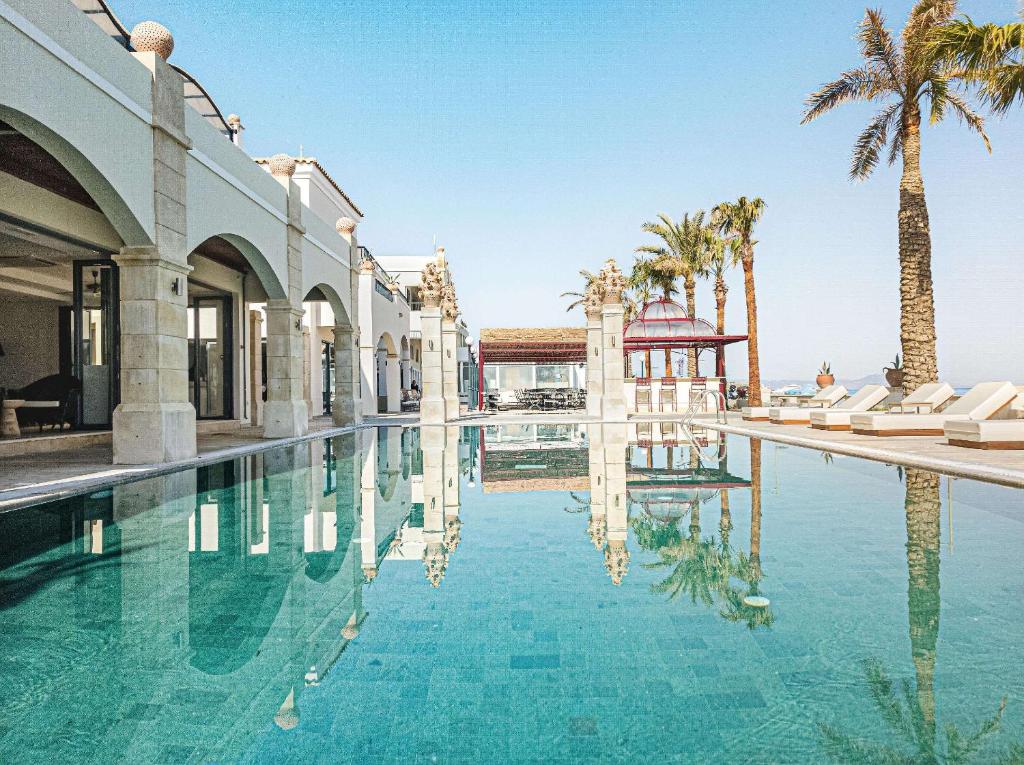 Grecotel Plaza Beach House pool with stone arches and palm trees