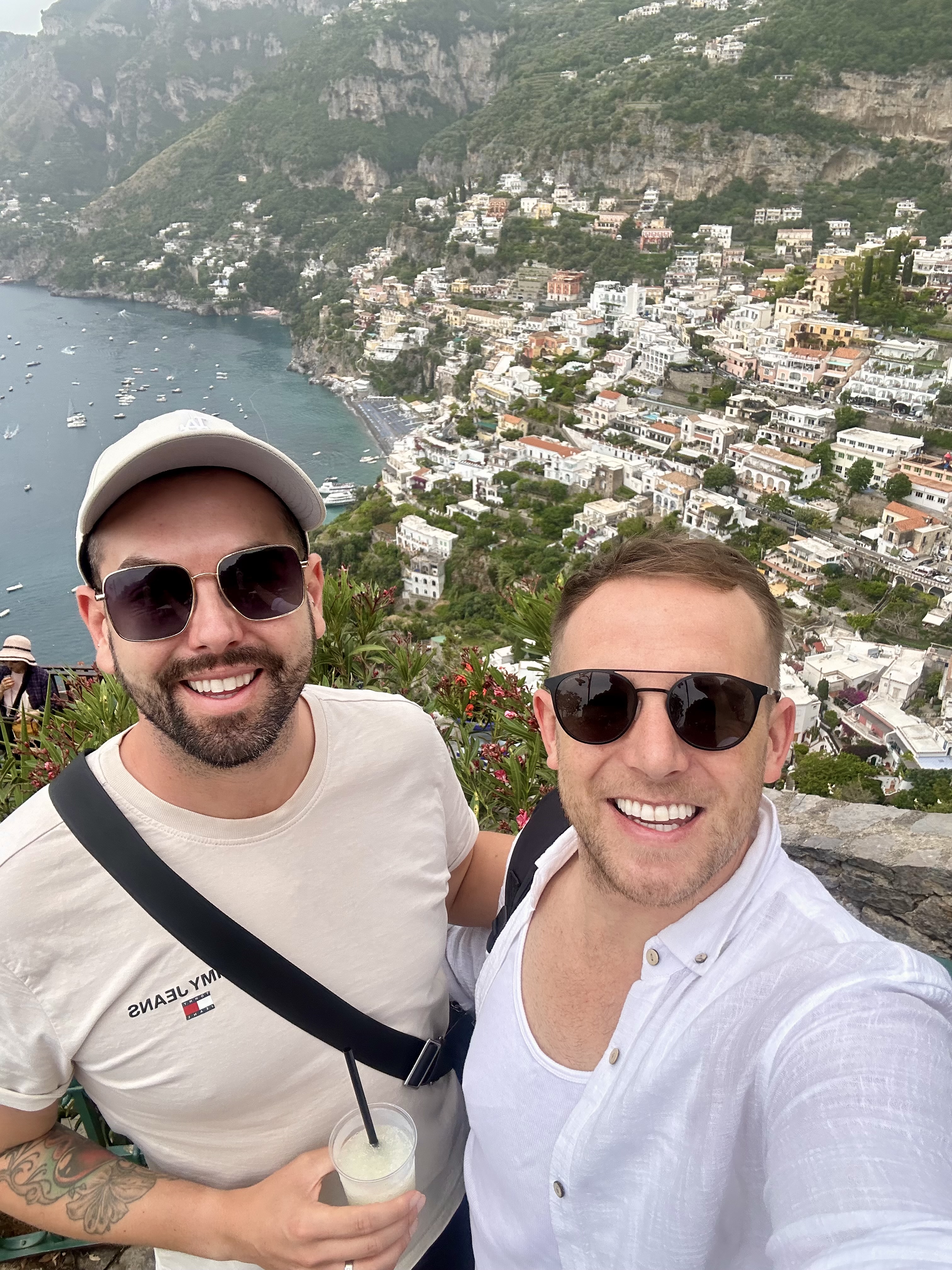 Mark and Mikey smiling above the colourful cliffside town of Positano