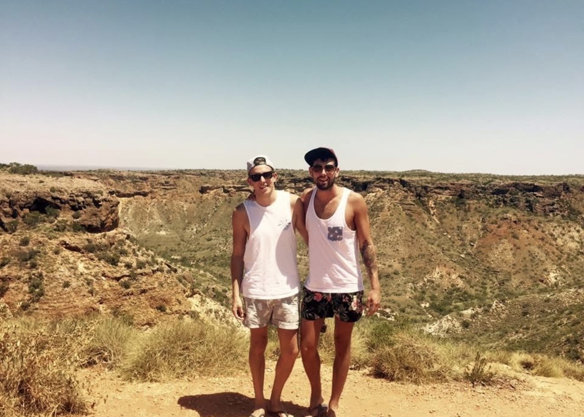 Mark and Mikey standing at the edge of a sun-baked canyon